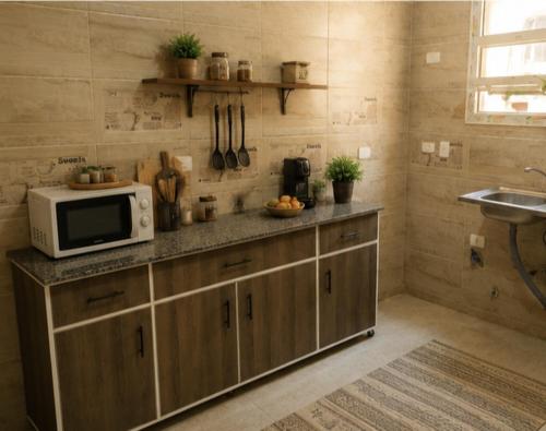 a kitchen with a counter with a microwave and a sink at Villa131 Hotel in Cairo