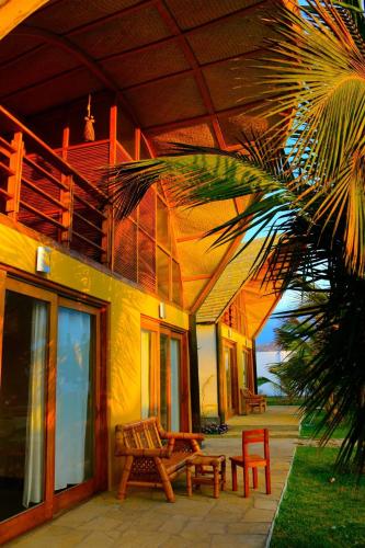 a house with a table and a bench on a patio at Kites Mancora in Máncora
