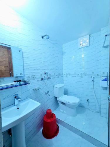 a white bathroom with a toilet and a sink at Coastal daisy Beach resort in Cox's Bazar