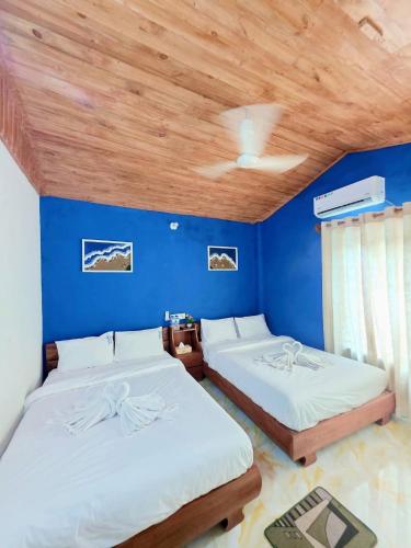two beds in a room with a blue wall at Coastal daisy Beach resort in Cox's Bazar
