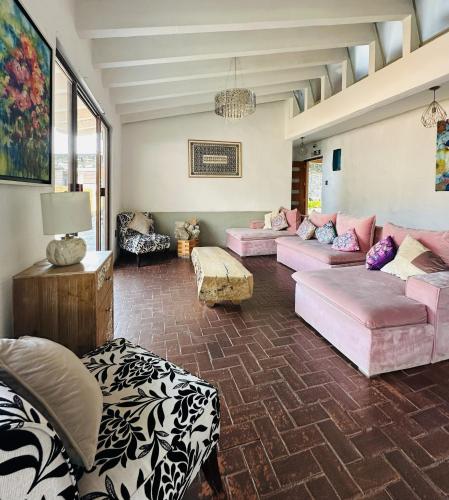 a large living room with pink couches and tables at Sierra Central By Chic Hotel Group in Tepoztlán
