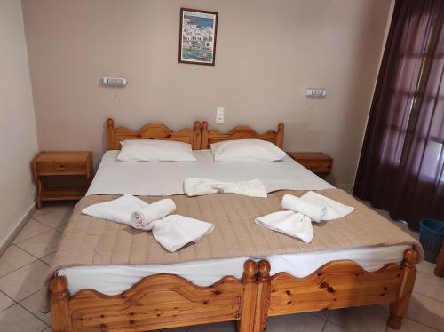 a bedroom with a wooden bed with towels on it at Ariadni Fountas Studios in Parga