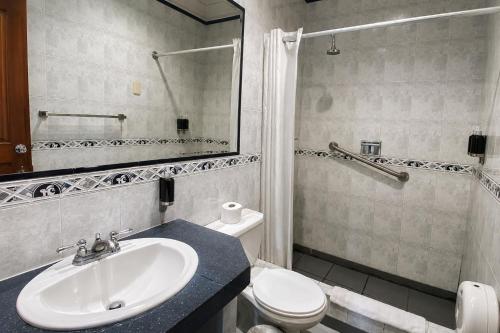 a bathroom with a sink and a toilet and a mirror at Cavi Rooms 304 in Cuenca