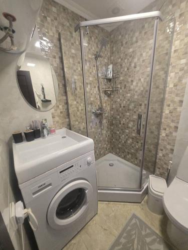 a bathroom with a washing machine and a shower at Baytur Resort таунхаус in Bosteri