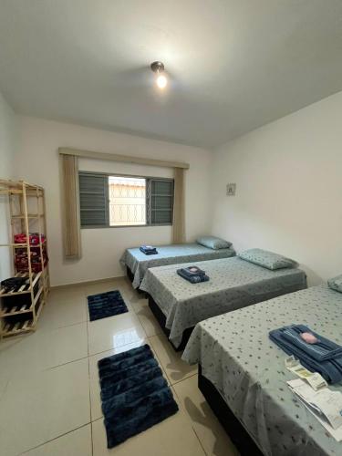 a room with three beds and a window at Casa Carregosa in São Roque
