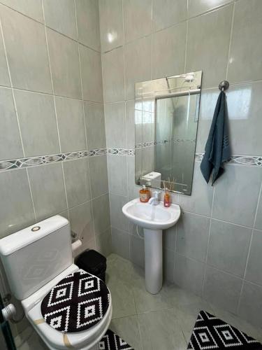 a bathroom with a white toilet and a sink at Casa Carregosa in São Roque