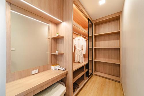 a walk in closet with wood paneling and a large mirror at Serene Pool Villa Pattaya 2 in Pattaya