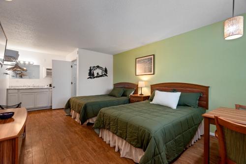 a hotel room with two beds and a kitchen at Trailhead Lodge in Eureka Springs