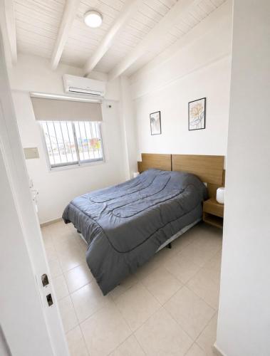 a bedroom with a bed and a window at Departamentos Centro in San Juan