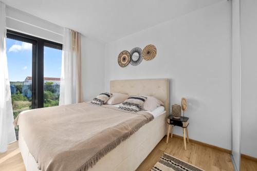 a bedroom with a bed with a large window at Boho Beach House Srima in Srima