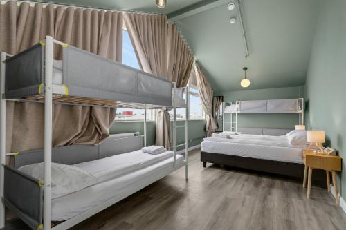a bedroom with two bunk beds and a window at ASKA Hraun in Hafnarfjörður