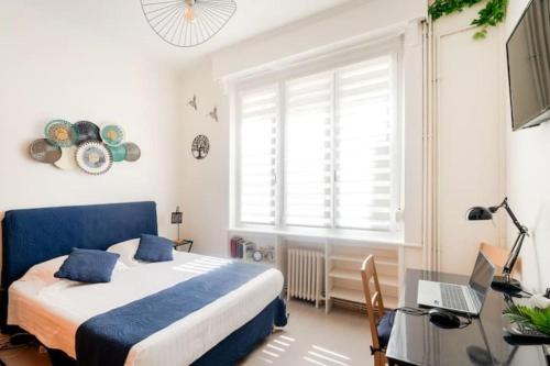 a bedroom with a bed and a desk with a laptop at Au Moulin d'Or in Lille