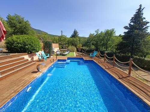 a swimming pool with a hammock in a yard at " LE CHABASSOLE " CHAMBRES D'HÔTES - GORGES du VERDON in Aiguines