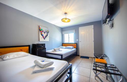 a bedroom with two beds and a table and chairs at Hostal Loco Coco Loco in Panama City