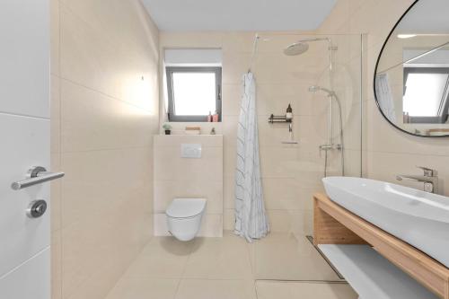 a white bathroom with a toilet and a sink at Boho Beach House Srima in Srima