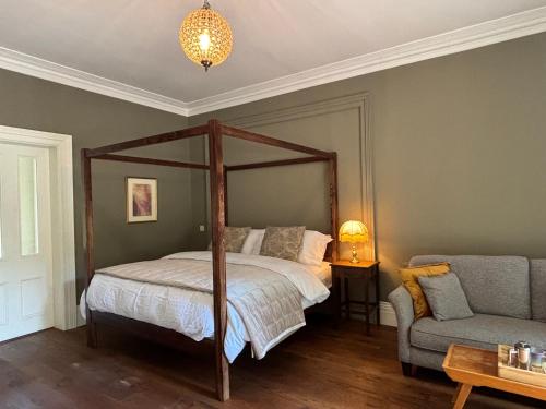 a bedroom with a canopy bed and a couch at Blackhill Woods Retreat in Abbeyleix