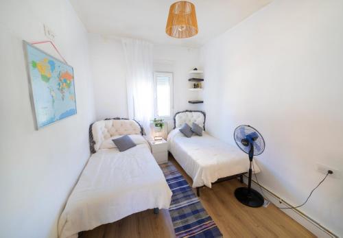 a bedroom with two beds and a fan at Casa Jardin Huesca Ciudad in Huesca