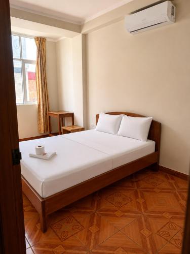 a bedroom with a large bed with white sheets at La Posada Del Pajarito in Yurimaguas
