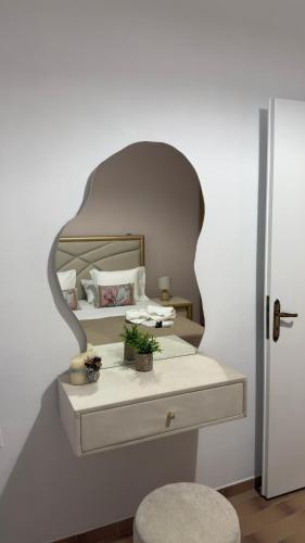 a bedroom with a bed with a mirror on the wall at Markella STONE & LIGHT Skoutari-Mani in Skoutari