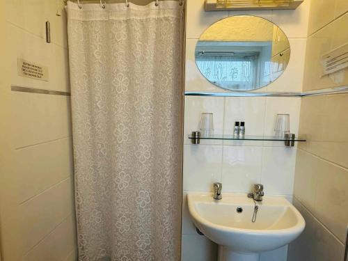 a bathroom with a sink and a shower curtain at Ride Side Delton Hotel in Blackpool