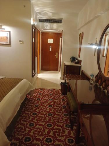 a hotel room with a bed and a hallway at Quetta Serena Hotel in Quetta