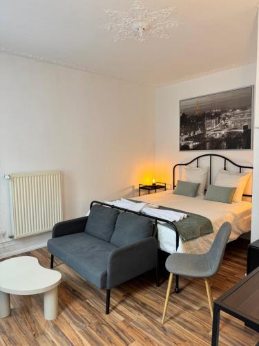 a bedroom with a large bed and a couch at Appart 3 pièce hyper centre Strasbourg in Strasbourg