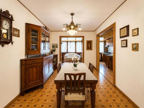 a dining room with a table and a clock at Zoncolan Mountain Lodge - Ride & Ski in Timau