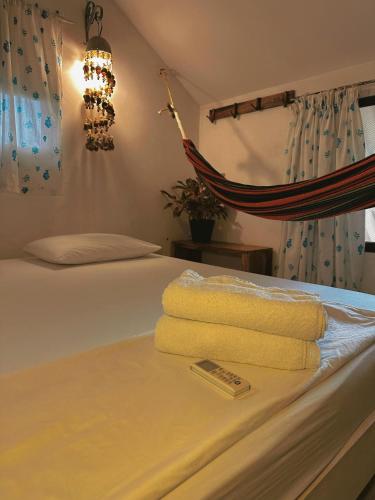 a bed with towels and a remote control on it at Mar Amar Casa de Playa in Coveñas