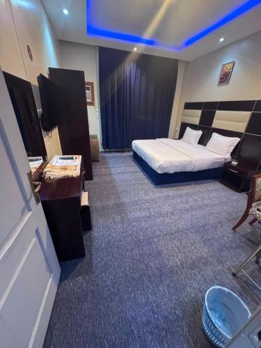 a hotel room with a bed and a television at سحابه صيف للشقق المخدومه - حي الاندلس - in Abha