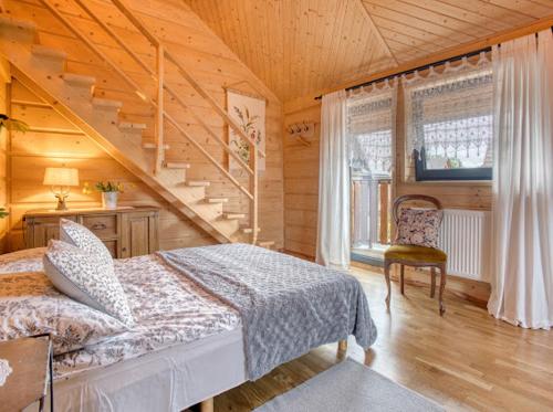 a bedroom with a bed and a staircase at Apartamenty Bąkowo Chatka in Witów