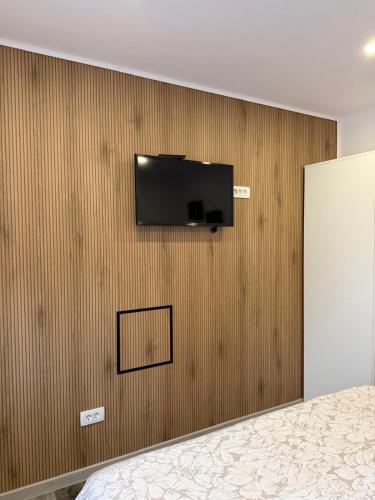 a bedroom with a television on a wall at Jetlag Bradić in Velika Gorica