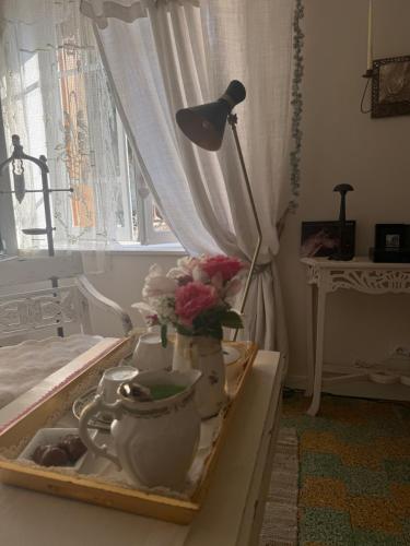 a table with a lamp and a tea set on it at La vallée des grottes in Saint-Germain-sur-Vienne