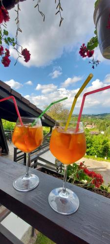 two cocktails sitting on a table with a view at Pensiunea Ursuleț Bran in Bran
