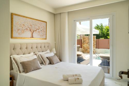 a bedroom with a white bed and a sliding glass door at Halkidiki Luxury Villa Palm Oasis Private Pool & Hot Tub in Nea Irakleia