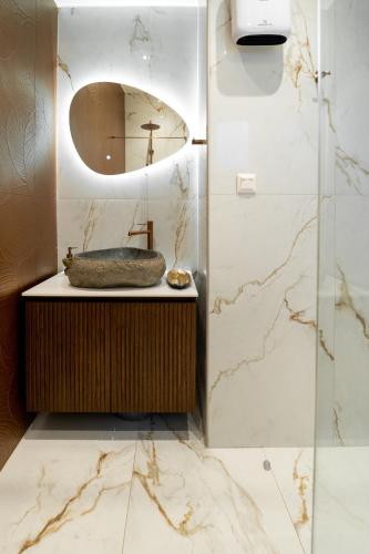 a bathroom with a sink and a mirror at Halkidiki Luxury Villa Palm Oasis Private Pool & Hot Tub in Nea Irakleia