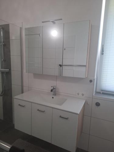 a white bathroom with a sink and a mirror at Haus Steiner in Kleblach