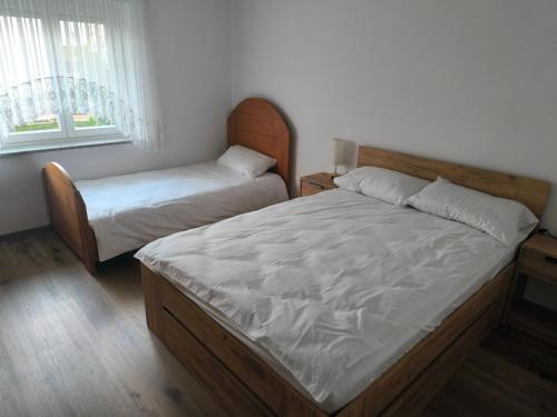 a bedroom with two twin beds and a window at Apartment Maria Domžale in Domžale