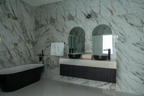 a bathroom with two sinks and a tub and mirrors at Emotions by Ironshore in Montego Bay