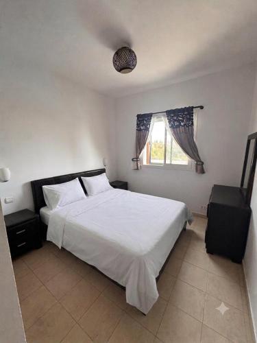 a bedroom with a white bed and a window at Mar y piscina in Cabo Negro