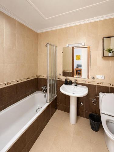 a bathroom with a tub and a sink and a toilet at Mar y piscina in Cabo Negro