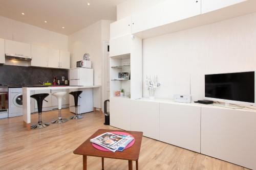 une cuisine avec des armoires blanches et une table dans une pièce dans l'établissement Apartment29, à Cannes