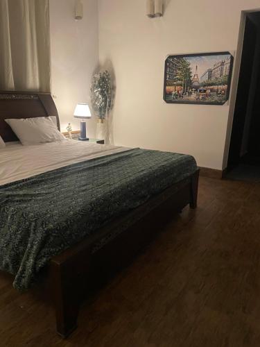 a bed in a bedroom with a picture on the wall at Executive Guest Room - Helcion Residency in Lahore