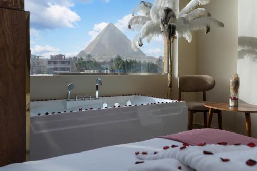 a bedroom with a view of the pyramids from a window at pyramids palace view With Rooftop Access in Cairo