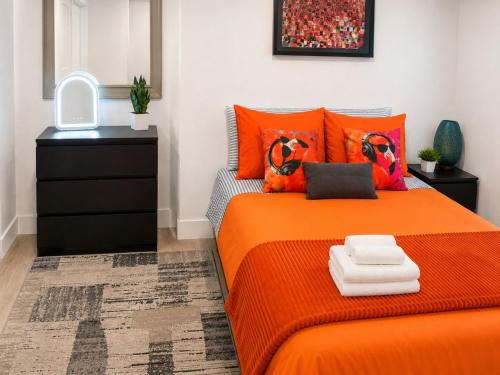 a bedroom with an orange bed and a dresser at Quiet & Centrally located House - PRIVATE PARKING, LAUNDRY AND STORAGE FOR LUGGAGE in Miami