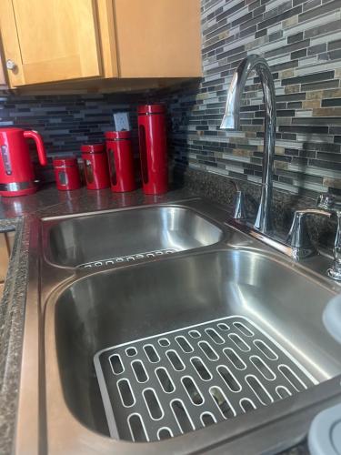 a sink in a kitchen with red cups on the counter at 2BR-Free parking, Near Gillette & Providence-I-95 in Pawtucket