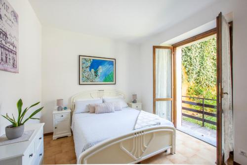 a white bedroom with a bed and a window at Da Mara Lago Di Como in Sormano