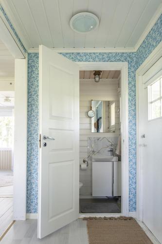 a bathroom with a white door and a sink at Villa Väderkulla in Porvoo