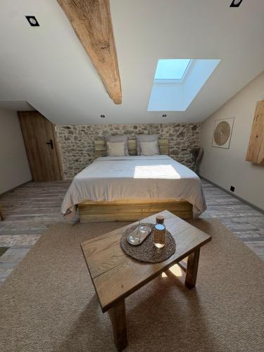 a bedroom with a large bed and a table at Chambre K-arole in Pouzauges