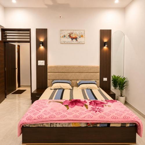 a bedroom with a large bed with a pink blanket at Amrit Farm in Rāi