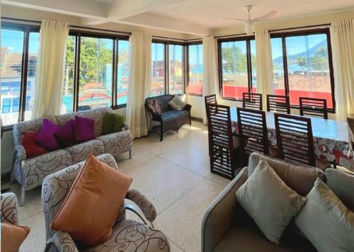 a living room with couches and a table and windows at Apartamento Vista ao Mar Maresias in Maresias